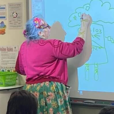 Vie writing on a white board to a group of students