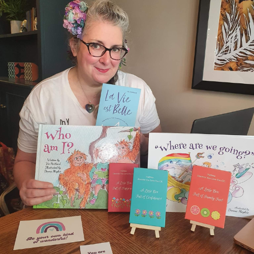 Vie smiling at the camera and sat with her book and confidence products.
